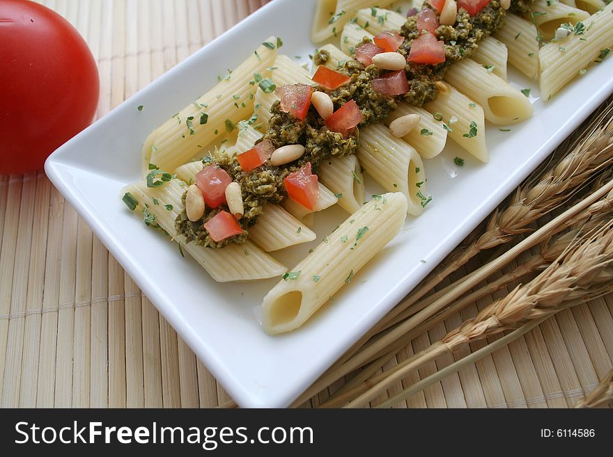 Fresh pasta with pesto, tomatoes and pine corns