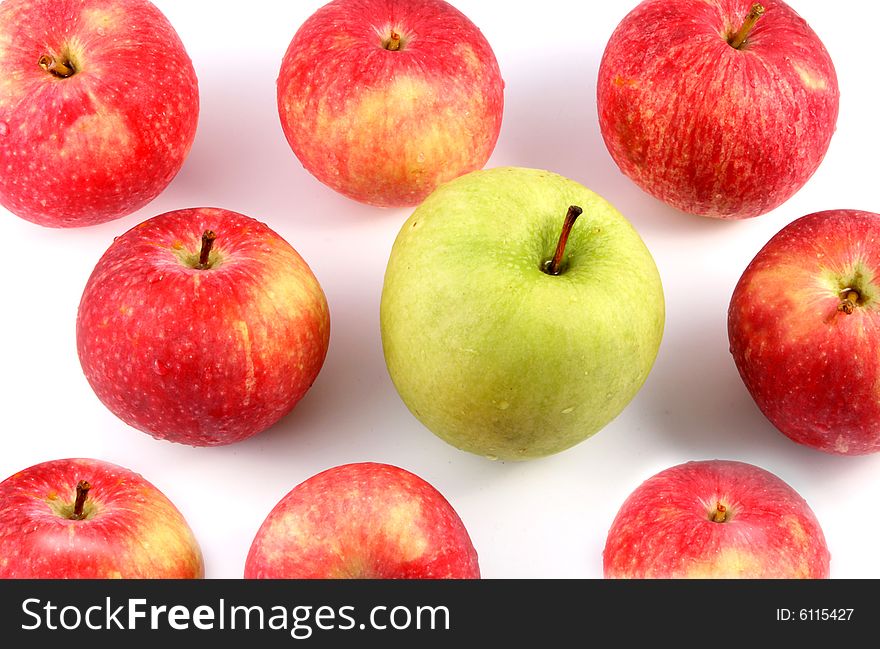 A lot of red and one green apple on a light background. A lot of red and one green apple on a light background