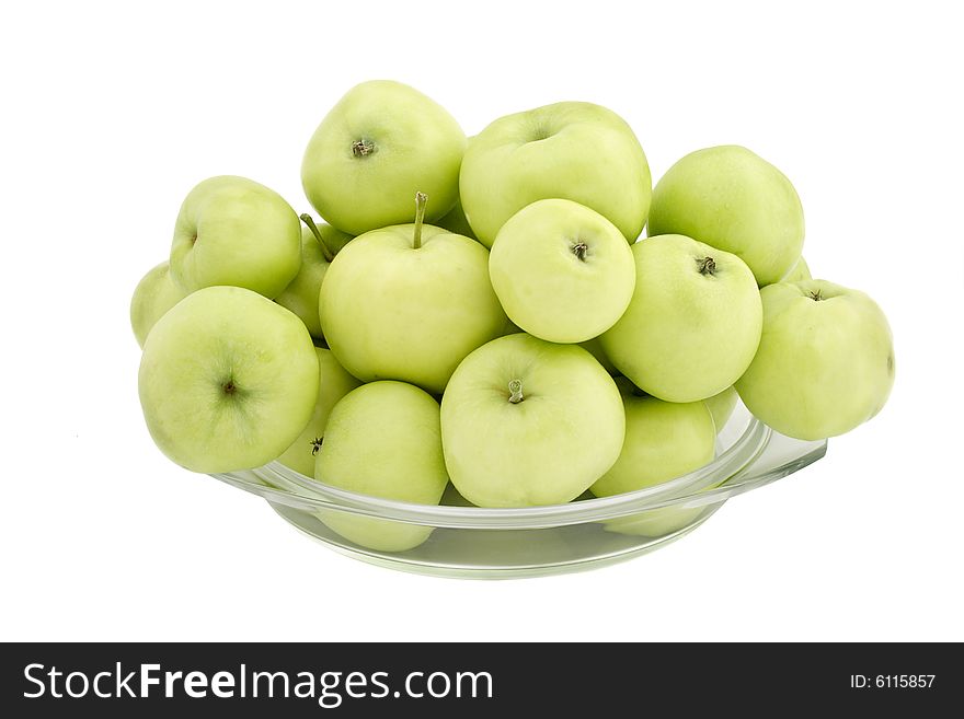 Green apples in a glass plate on a white background. Green apples in a glass plate on a white background