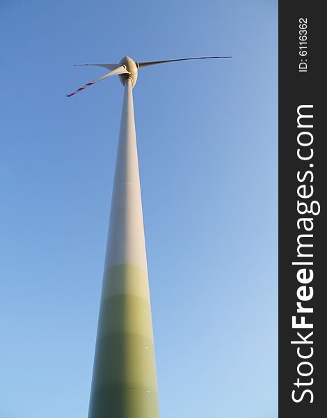 Single wind turbine over blue sky. Alternative energy source. Single wind turbine over blue sky. Alternative energy source.