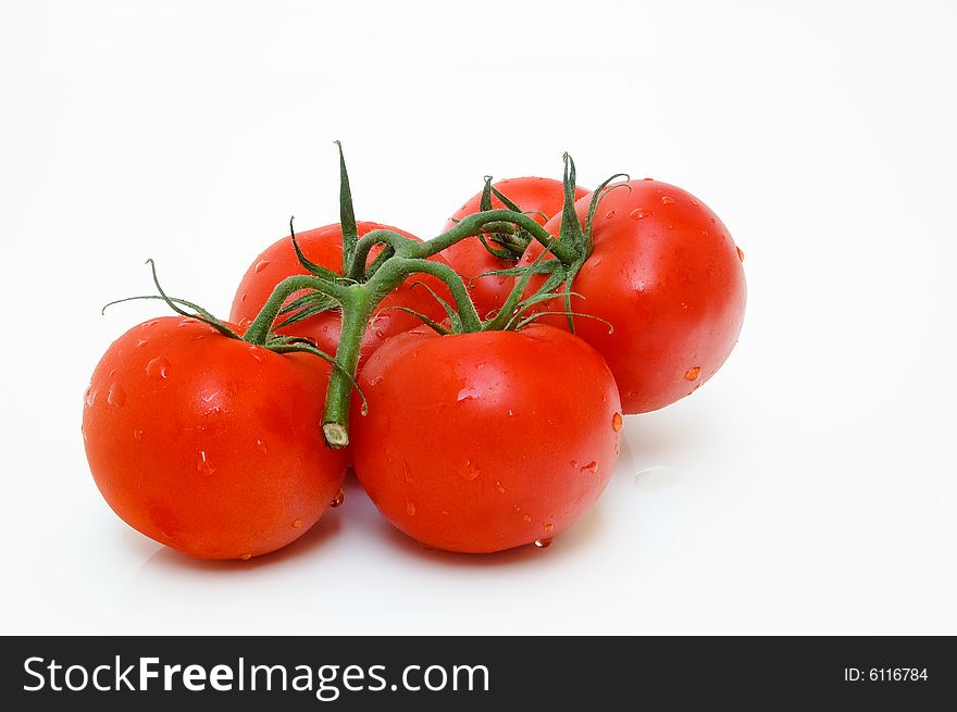 Group of red tomatoes with leaves, isolated on white background