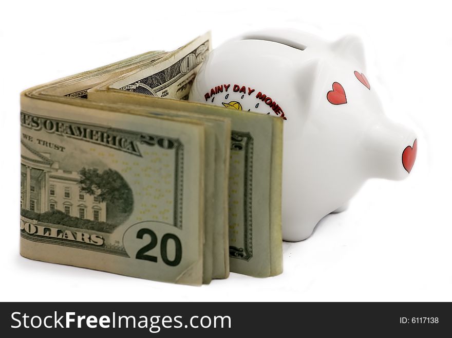 Piggy bank with a stack of twenty dollar bills, isolated on white