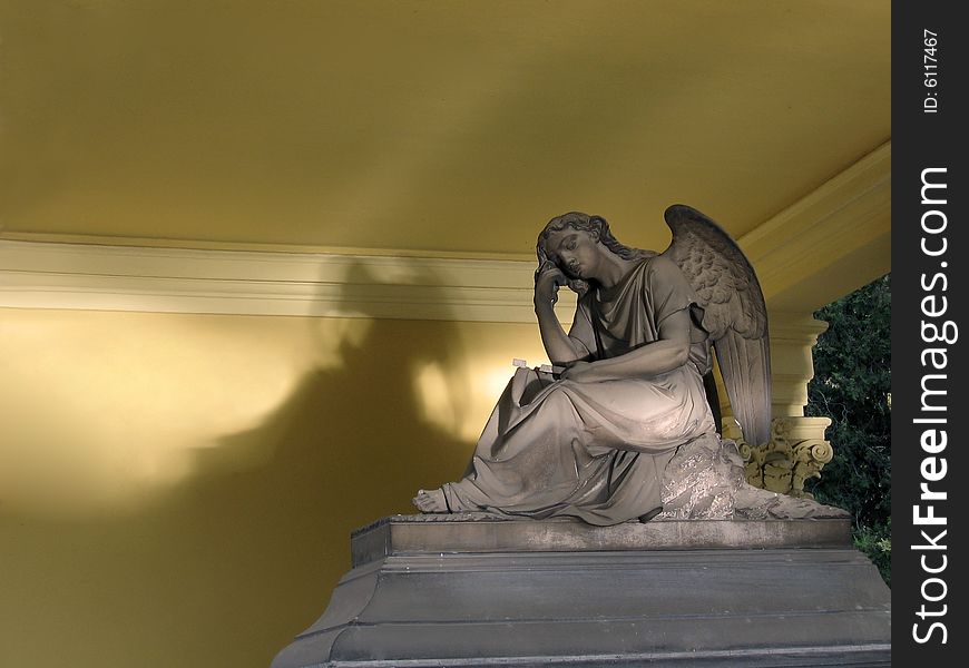 A statue of an angel on top of a tomb. A statue of an angel on top of a tomb