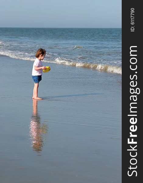 Little girl with reflection playing on beach. Little girl with reflection playing on beach