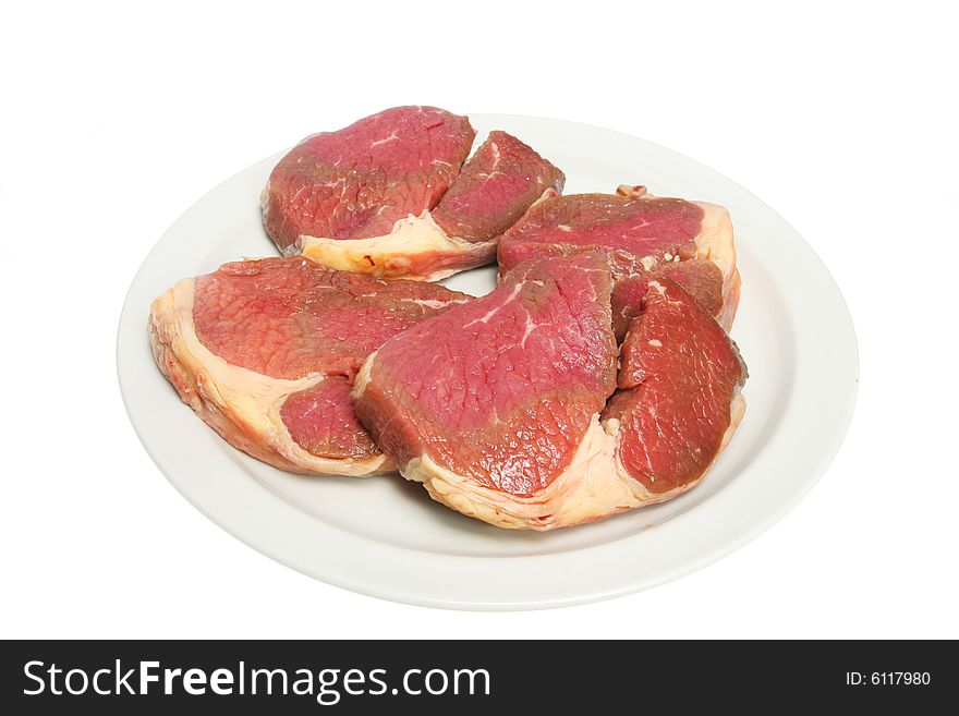 Raw steak on a white plate
