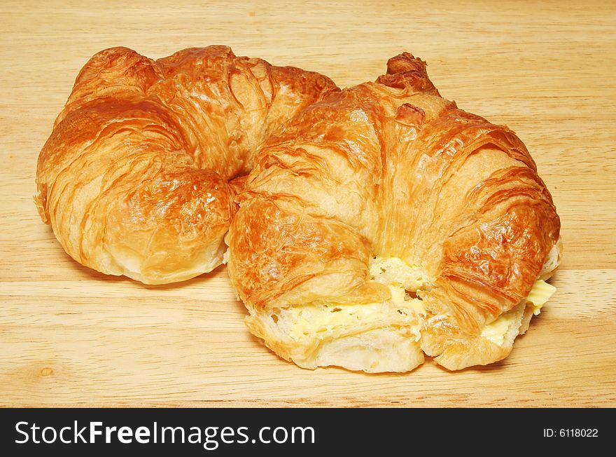 Two croissants on a wooden bread board