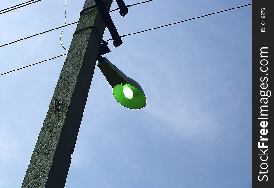 Column, street lamp and wires on a background of the sky