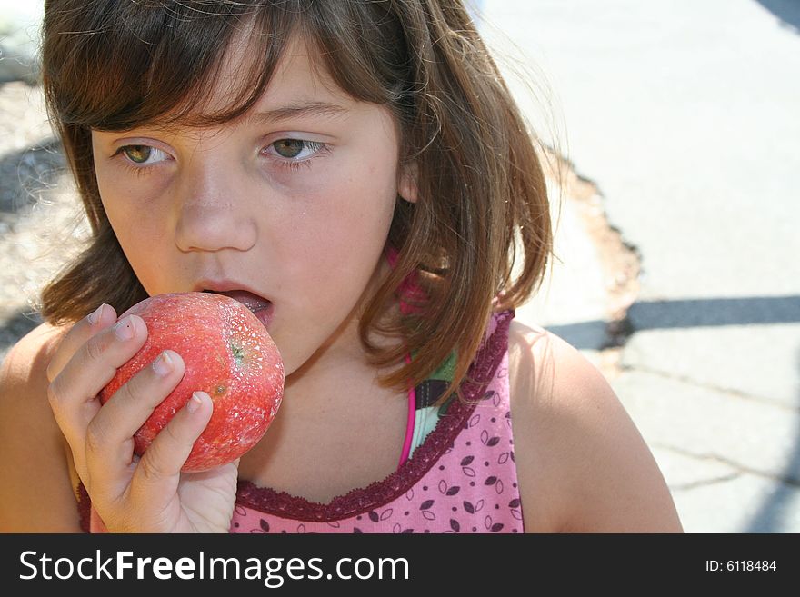 Young girl biting into an apple. Young girl biting into an apple.