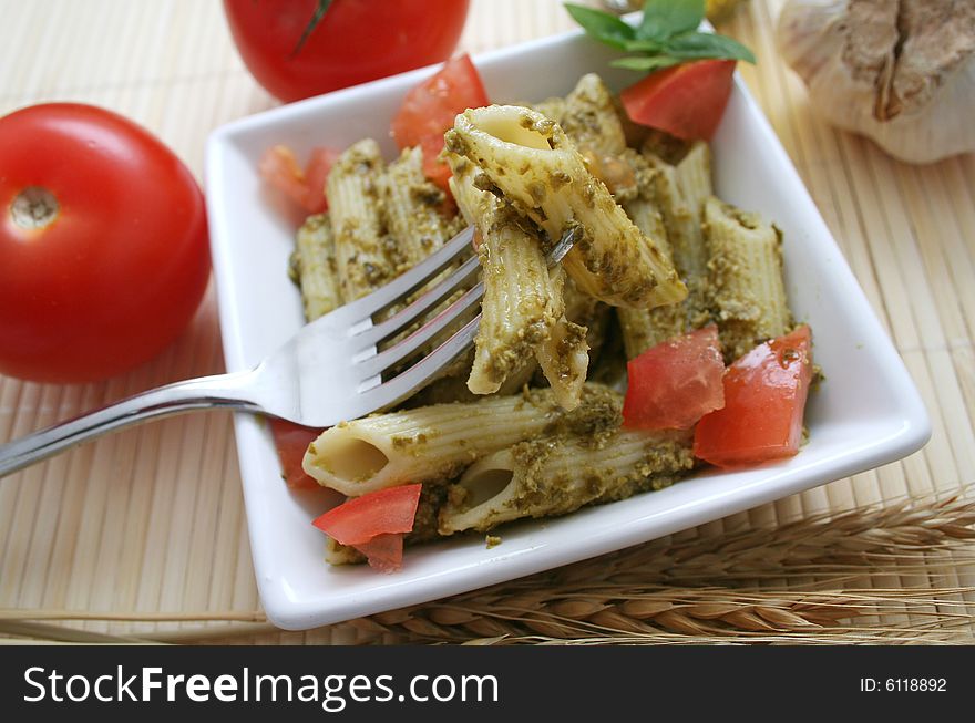 A meal of fresh noodles with pesto and tomatoes. A meal of fresh noodles with pesto and tomatoes
