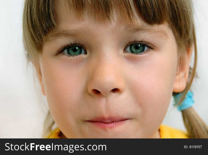 A little beautiful child (girl) gives a look 
Child's head on white background. A little beautiful child (girl) gives a look 
Child's head on white background.