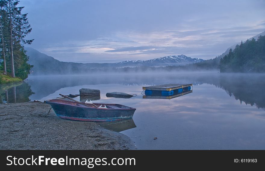 Boat on the shore of the mountain lake in early morning. Boat on the shore of the mountain lake in early morning