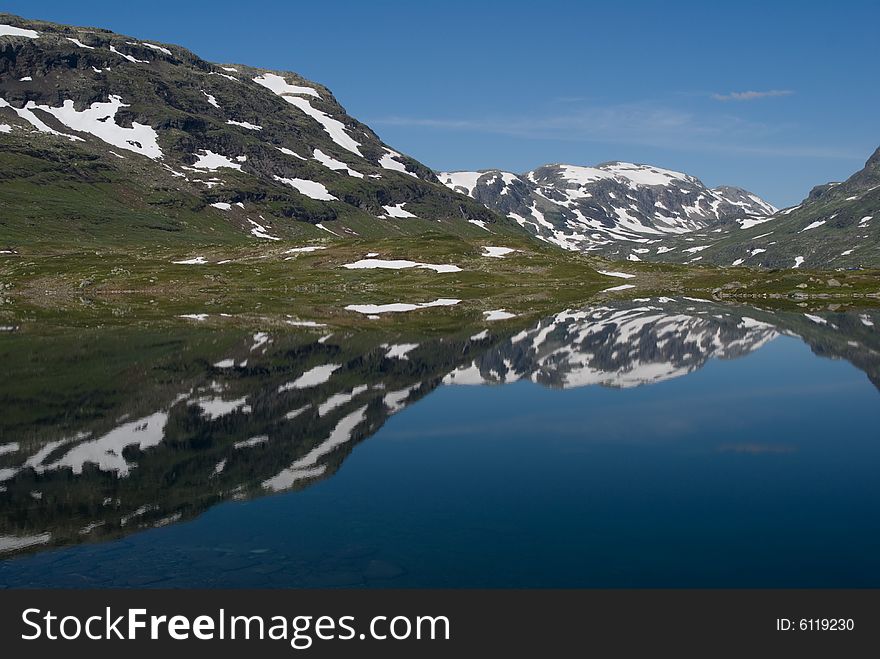 Reflected mountains on smooth surface of the blue lake. Reflected mountains on smooth surface of the blue lake.