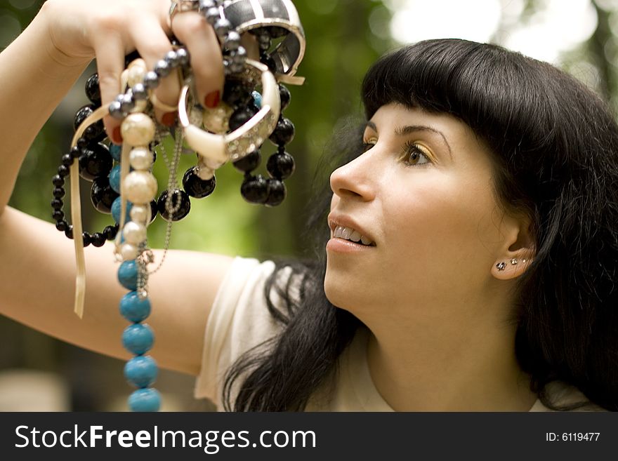 Closeup portrait on young brunette holding a lot of beads