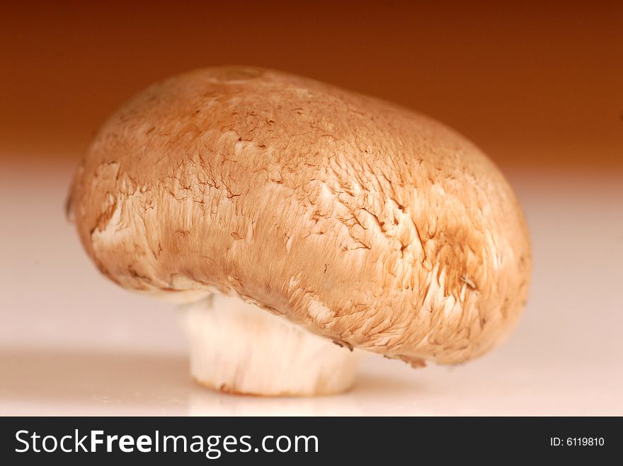Fresh organic crimini mushroom on a brown background