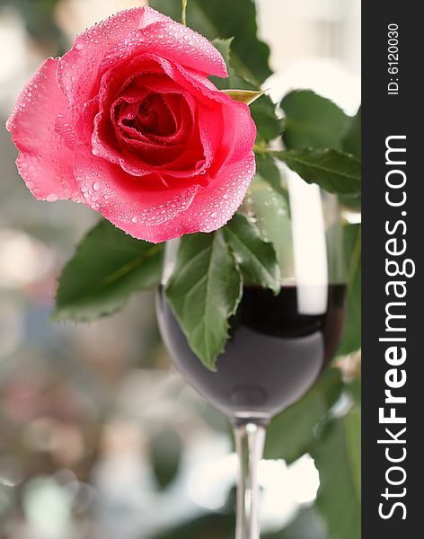 Red rose on red wine glass, bright background, shallow DOF. Red rose on red wine glass, bright background, shallow DOF