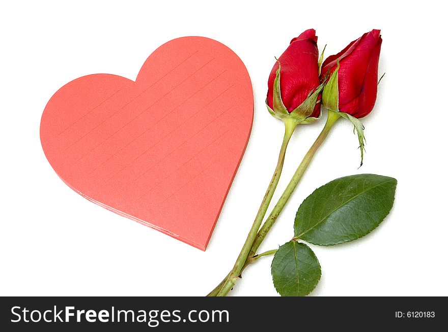 Love note in heart shaped pad next to a couple of red roses. Love note in heart shaped pad next to a couple of red roses