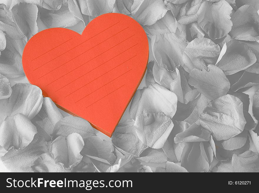 Love note in heart shaped pad surrounded by beautiful petals. Love note in heart shaped pad surrounded by beautiful petals