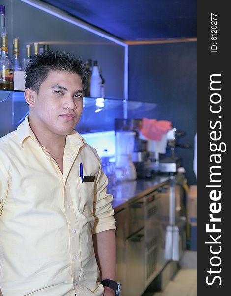 Photograph of bartender at work near by whisky bottles