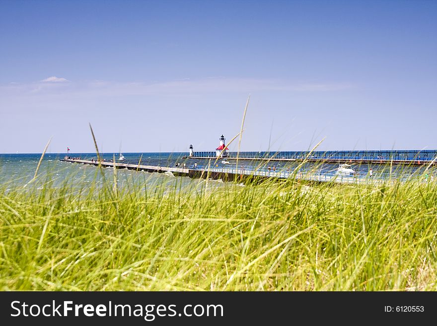 Piers at the harbor entrance to St. Joseph, Michigan, with out of focus dune grass in foreground. Piers at the harbor entrance to St. Joseph, Michigan, with out of focus dune grass in foreground.