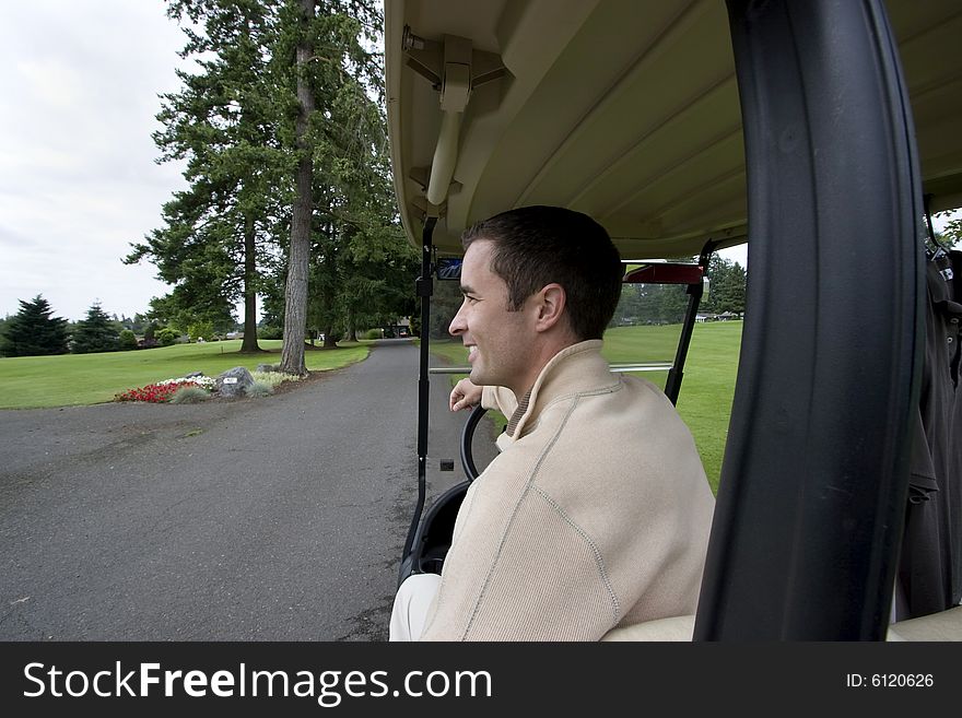 Man smiling as he sits in golf cart. Horizontally framed photo. Man smiling as he sits in golf cart. Horizontally framed photo.