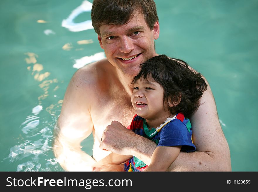 Father swimming with toddler in pool. Father swimming with toddler in pool