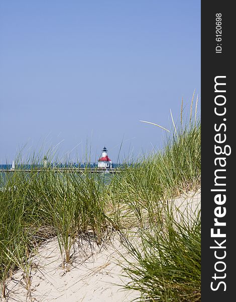 Dune grass and sand in foreground with lighthouse out of focus in background at St. Joseph, Michigan. Dune grass and sand in foreground with lighthouse out of focus in background at St. Joseph, Michigan