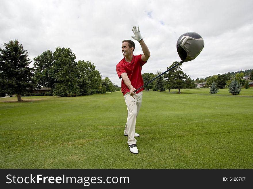 Happy golfer waving and holding his club out far away from him. Horizontally framed photo. Happy golfer waving and holding his club out far away from him. Horizontally framed photo.