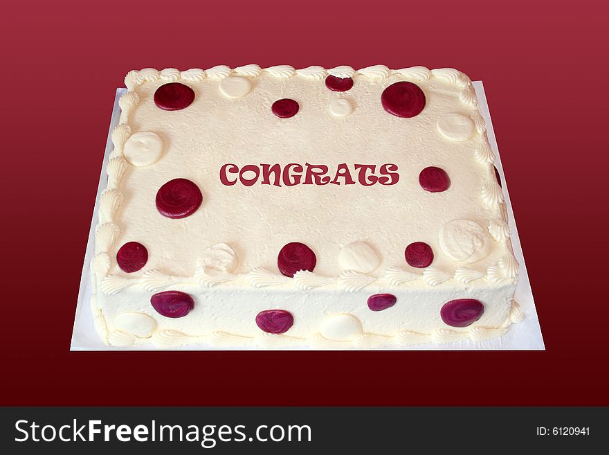 A creme cake with burgundy spots has congrats written on it. A creme cake with burgundy spots has congrats written on it.