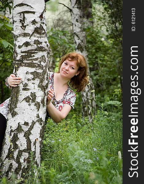 The girl looks out from a birch