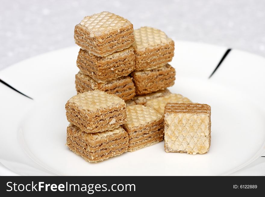 Cappuccino cream filled wafer cubes stacked on a white plate.
