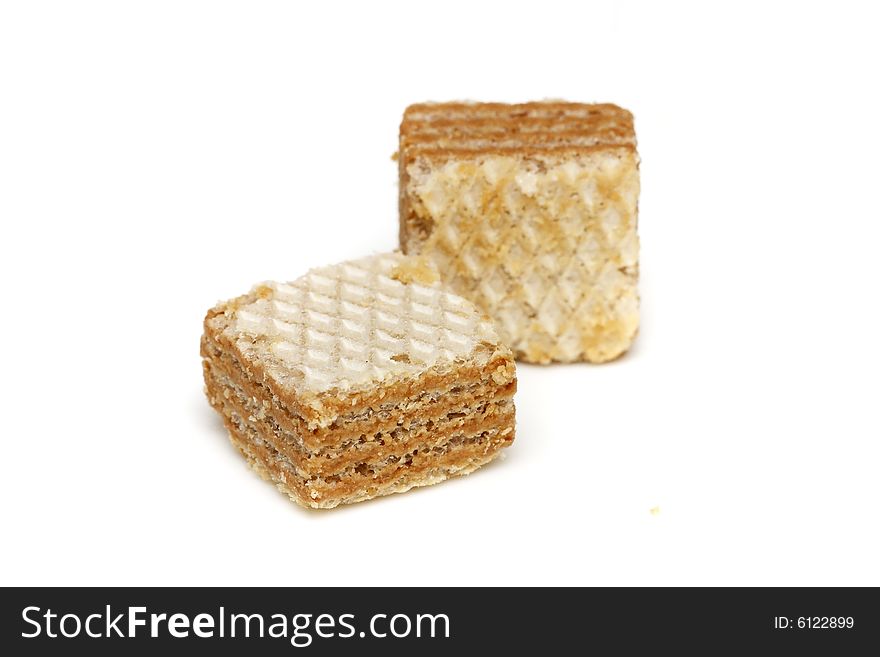 Two pieces of cappuccino cream filled wafer cubes on white background.