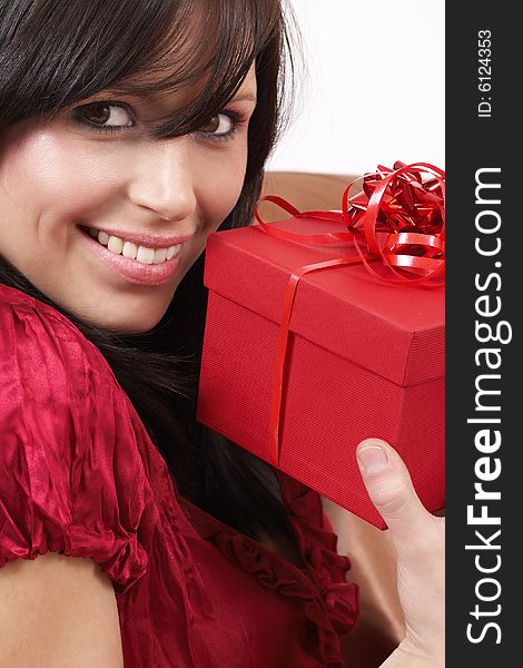 Portrait of a beautiful young brunette woman holding gift box at a celebration. Portrait of a beautiful young brunette woman holding gift box at a celebration