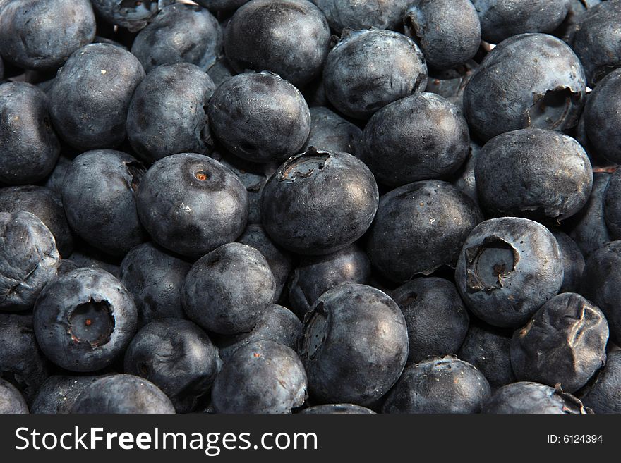 Ripe black currant on a grey background