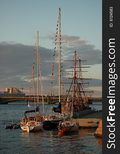 Boats and sailing-vessel on the river by a summer warm, sun evening