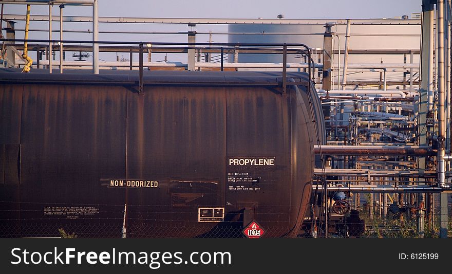 Propylene Chemical tank train car in front of refinery pipes. Propylene Chemical tank train car in front of refinery pipes