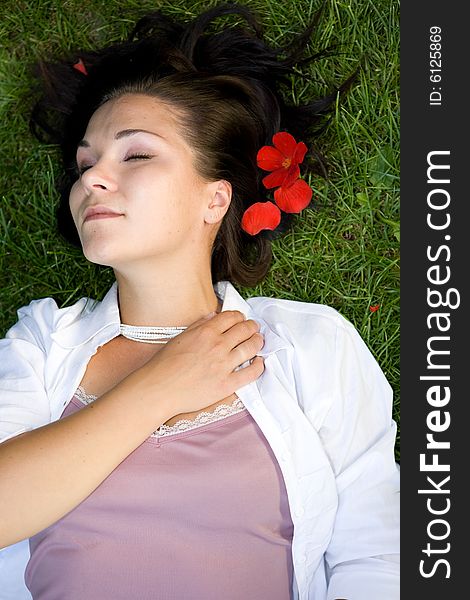 Attractive brunette woman lying on grass. Attractive brunette woman lying on grass