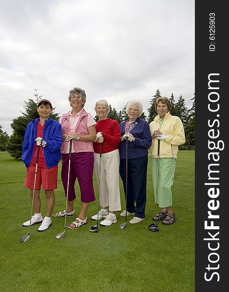 Five smiling, elderly women carrying golf clubs. Vertically framed photo. Five smiling, elderly women carrying golf clubs. Vertically framed photo.