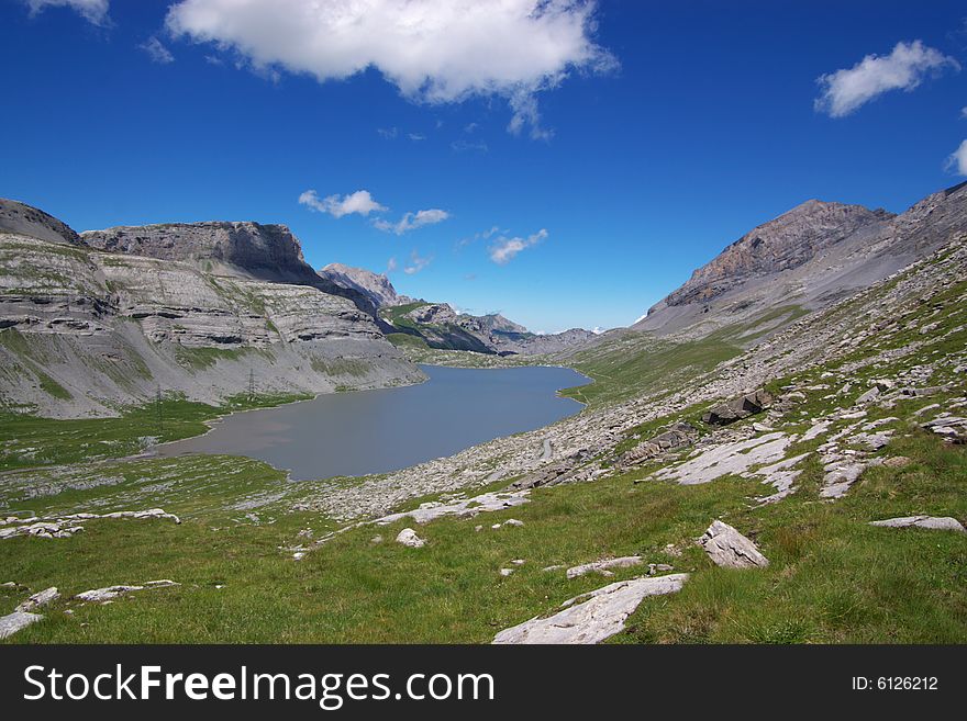 A panoramic view on rocky mountains and lake in Swiss Alps, horizontal. A panoramic view on rocky mountains and lake in Swiss Alps, horizontal.