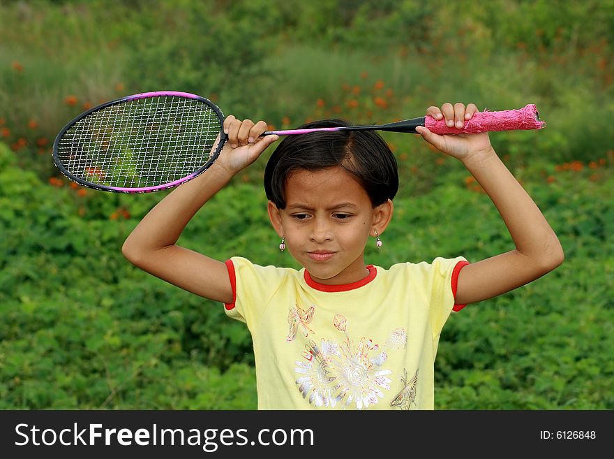 A sweet little girl thinking deep about her future badminton play. A sweet little girl thinking deep about her future badminton play.