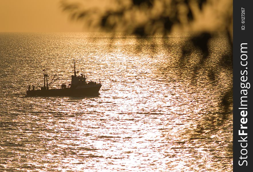 Small Fishing Ship Floating On Sunset