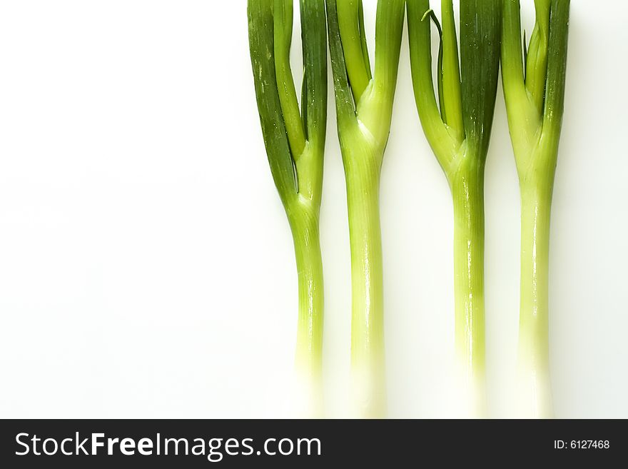Stack of fresh green onions on a white background. Stack of fresh green onions on a white background.