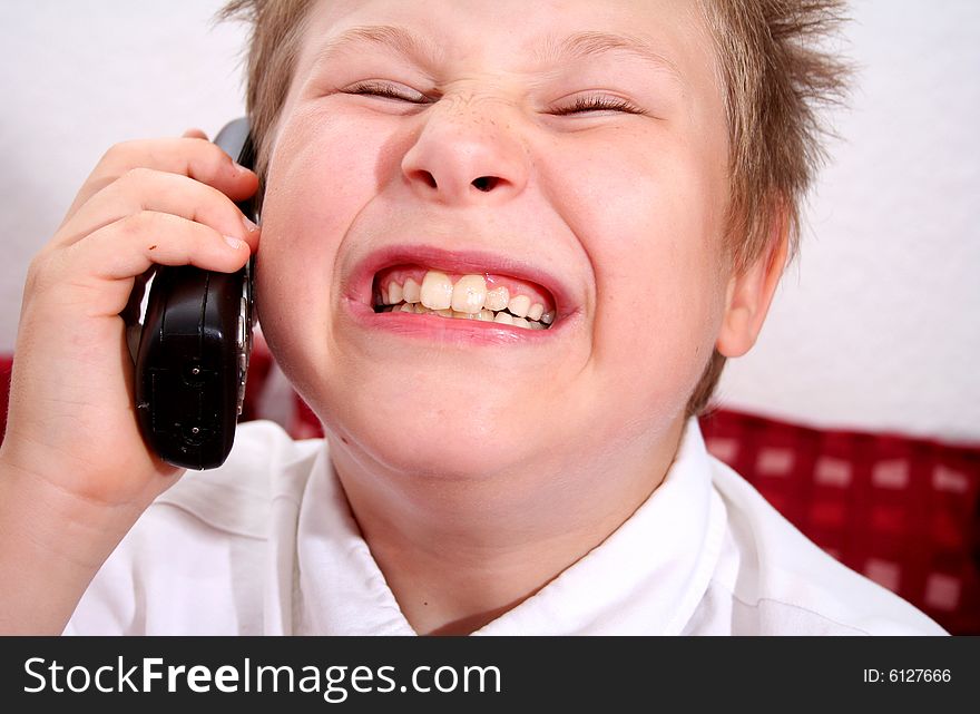 A young boy with an phone and a tie. A young boy with an phone and a tie