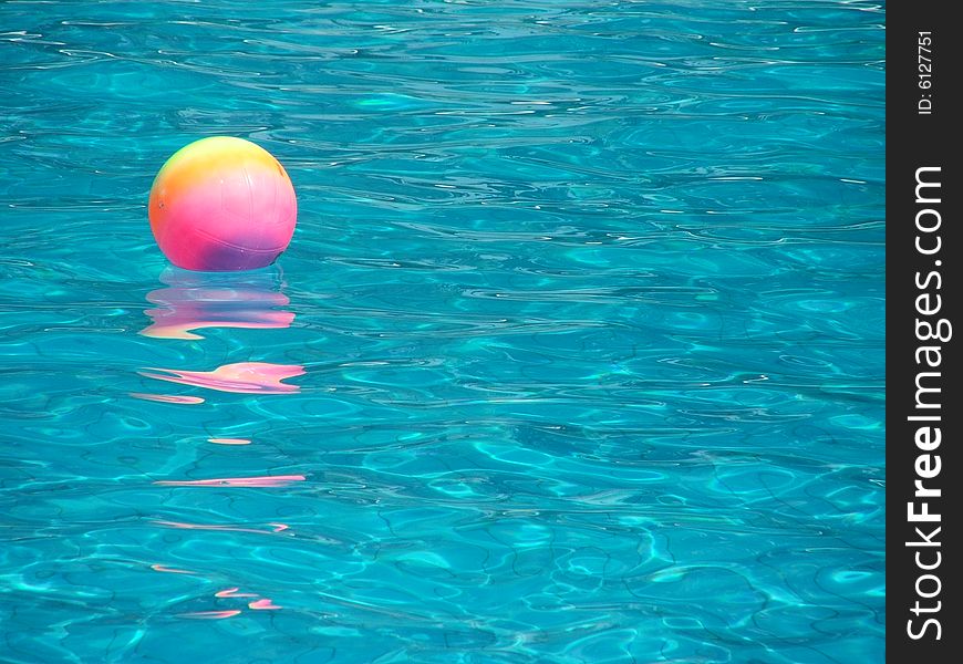 Rainbow-colored ball in swimming pool. Rainbow-colored ball in swimming pool