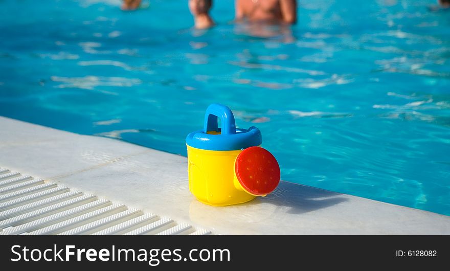 Cute child's watering-can at the pool