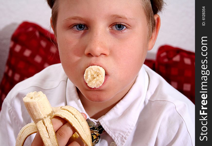 A young boy is eating a banana