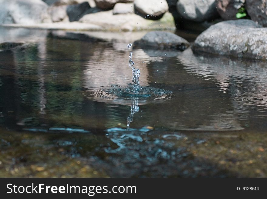 Water splash in rocky pond