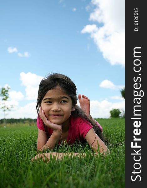 Little Girl Lying On Grass