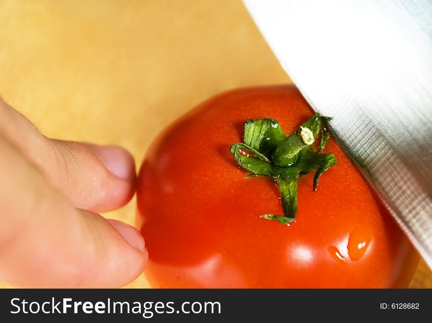 Cutting of tomato on wooden desk