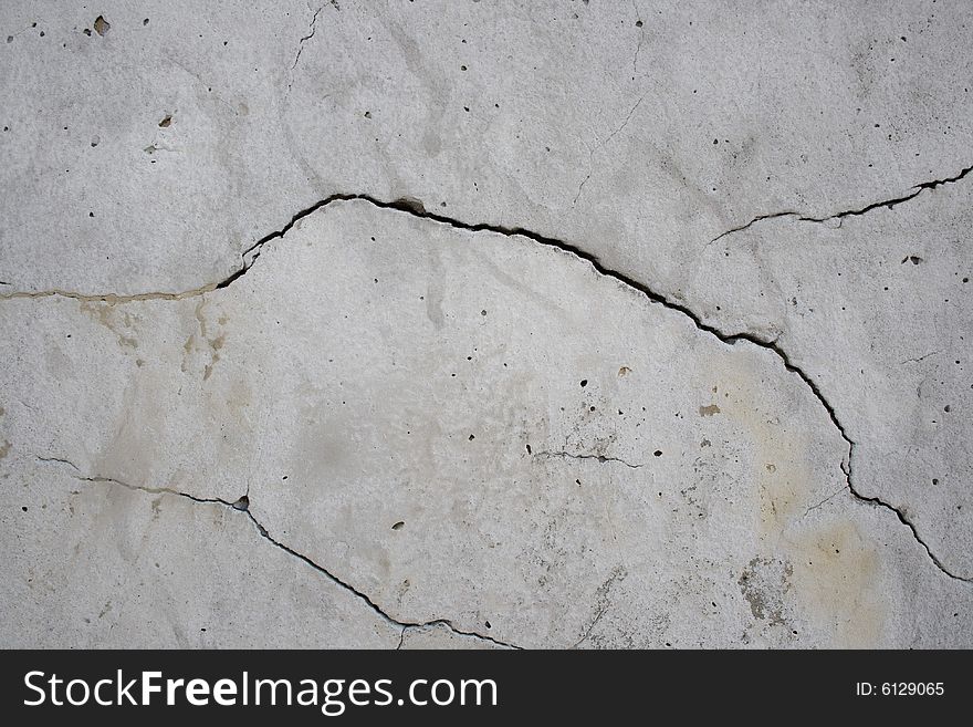 Cracks on the grey wall surface