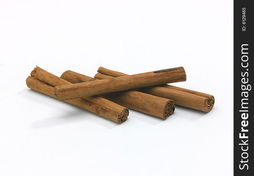 An arrangement of three Cinnamon sticks on clean white background